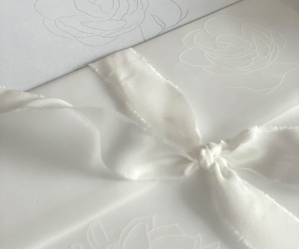 Papeterie-Serie Elegance, Einladungskarte zur Hochzeit mit Transparentumschlag und Seidenband, dazu Briefumschlag mit Envelopeliner, darauf Initialen des Brautpaares